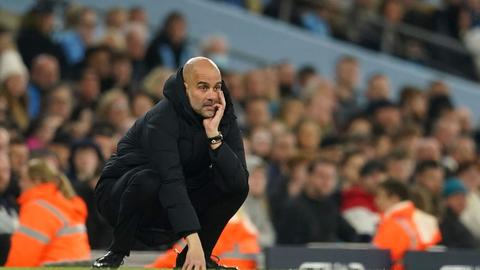 Pep Guardiola, Trainer von Manchester City, hockt an der Seitenlinie und studiert das Spiel seiner Mannschaft.