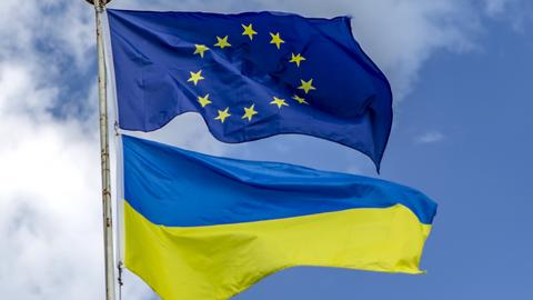 Eine EU-Flagge weht über einer Ukraine-Flagge