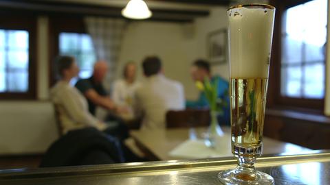 Ein Glas mit Bier steht am Tresen in einer Gaststätte.