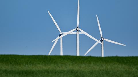 Windräder hinter einem Hügel