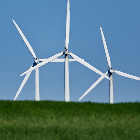 Windräder hinter einem Hügel