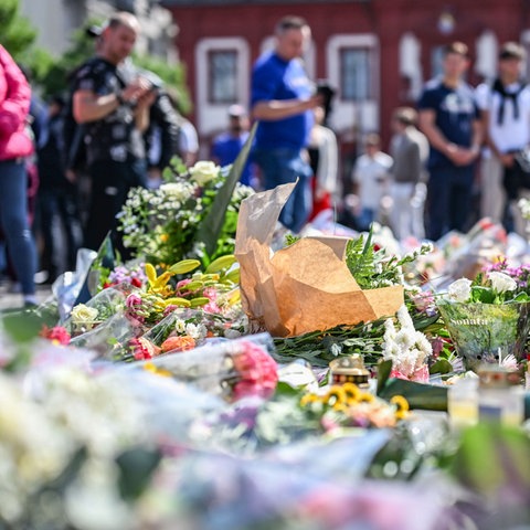 Nach dem Tod eines Polizisten liegen am Marktplatz in Mannheim in der unmittelbaren Nähe des Tatorts Blumen und Kerzen.