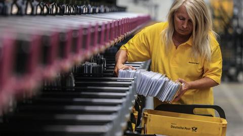 Eine Mitarbeiterin der Deutschen Post DHL sortiert Briefe im Briefverteilzentrum.