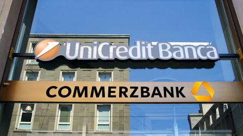 Die Logos von Commerzbank Unicredit über einer Glastüre.