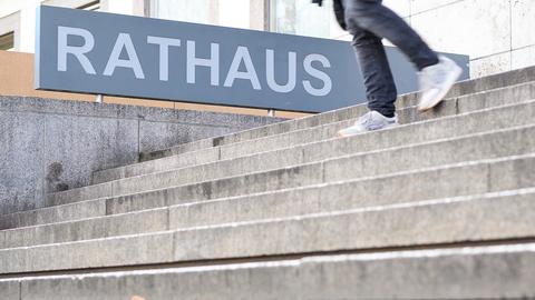 Ein Schild mit der Aufschrift "Rathaus" ist neben einer Treppe zu sehen.