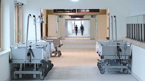 Krankenbetten stehen im Flur einer Krankenhaus-Station. 