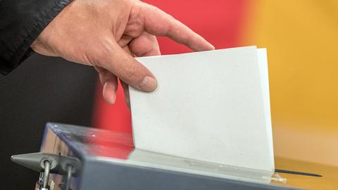 Ein Wähler wirft seinen Stimmzettel zur Bundestagswahl in die Wahlurne.