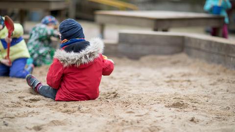 Kinder spielen in einer Sandkiste einer Kita.