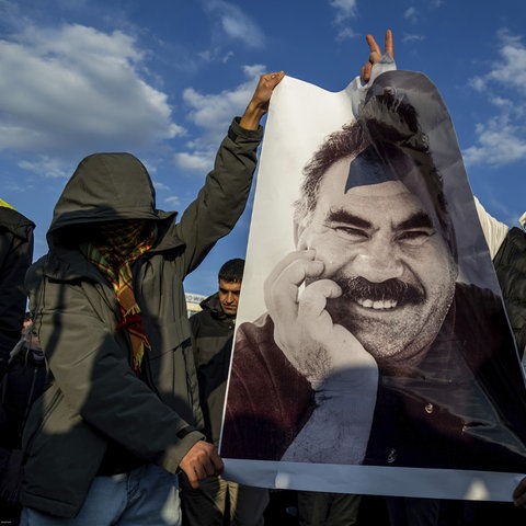 Vermummte Menschen zeigen Öcalan-Bild