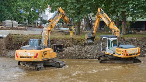 Bagger reißen Teile einer durch die Flut zerstörte Brücke über der Ahr ab. (dpa)