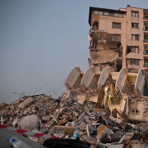 Sicherheitskräfte vor einem zerstörten Gebäude nach schweren Erdbeben in Syrien und der Türkei (dpa)