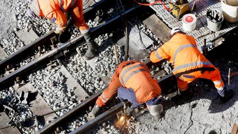 Bauarbeiter der Bahn reparieren auf der Strecke zwischen Essen und Duisburg das Gleisbett.