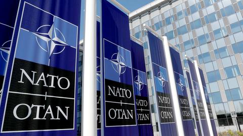 Fahnen mit dem Logo der NATO wehen vor dem NATO-Hauptquartier in Brüssel