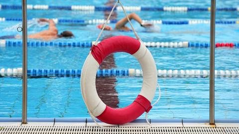 Ein Rettungsring hängt in einem Freibad am Rand des Beckens