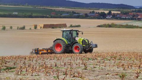 Maisernte, Bauer mit Traktor und Maishäcksler, das Feld ist zum Teil vertrocknet