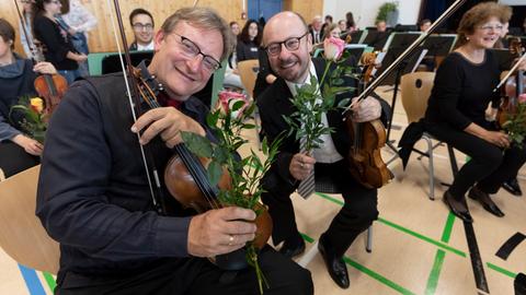 Zwei Musiker mit Blumen, die ihnen geschenkt wurden