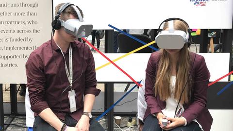 Ein Mann und eine Frau probieren die VR-Brillen aus 