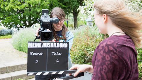 Zwei Schülerinnen mit einer Filmklappe