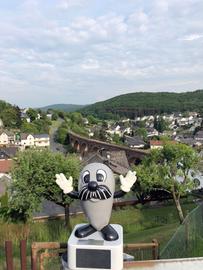 Onkel Otto auf einer Wiese, hinter ihm ein Tal mit einer schönen Stadt.